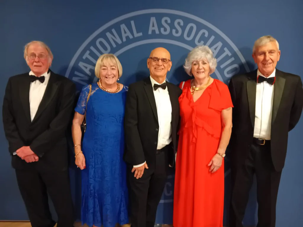Five NARPO members in evening dress in front of the National Association of Retired Police Officers backdrop at the 2026 conference