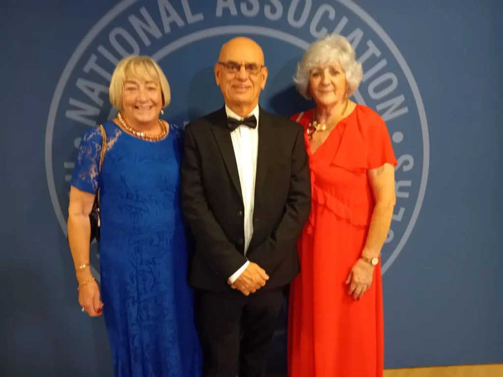 Three NARPO members in evening dress in front of the National Association of Retired Police Officers backdrop at the 2026 conference